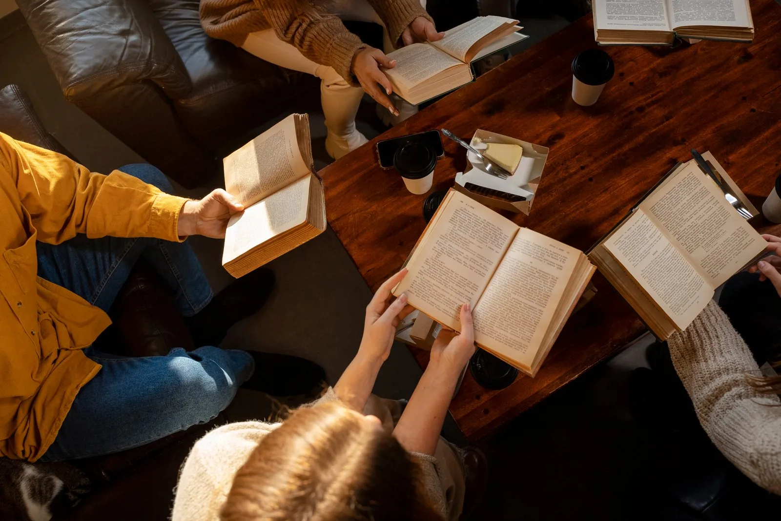 Students reading books together around a table